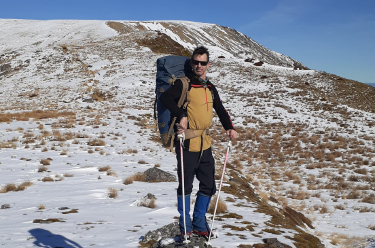 Man tramping in the hills with a back pack - early detection of prostate cancer saves lives